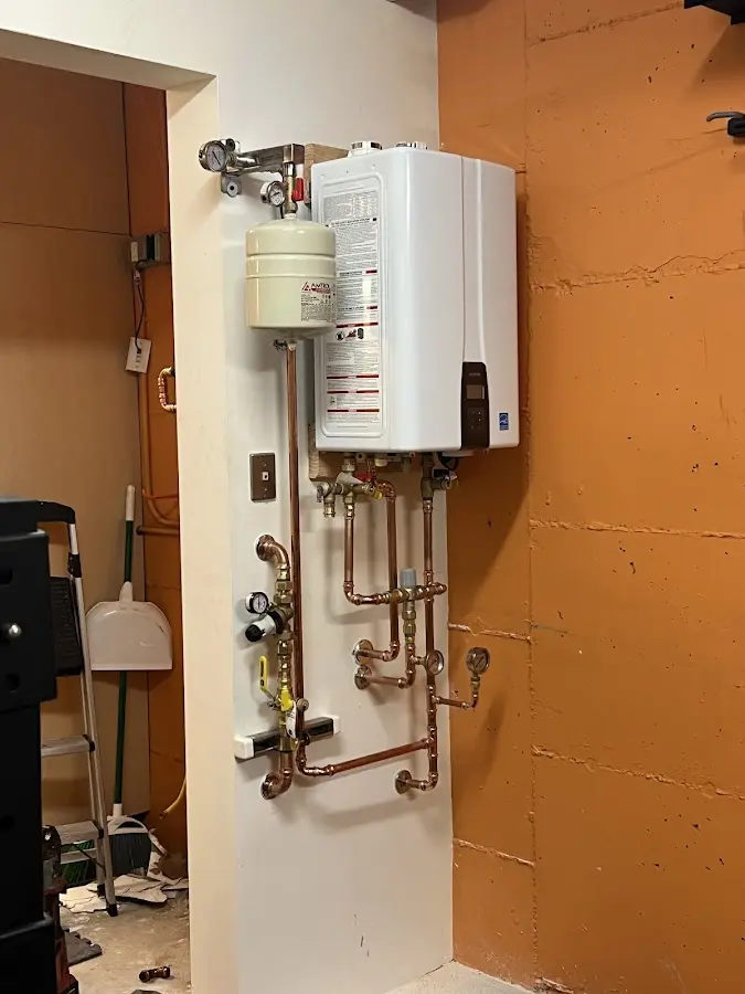 Plumbing technician inspecting water heater connections in Dickson